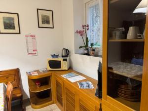 uma cozinha com uma secretária, um micro-ondas e uma televisão em Casa al mare con parcheggio em Génova