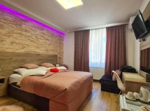 een slaapkamer met een groot bed met paarse verlichting bij Ginko Rooms in Daruvar