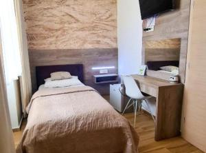 een slaapkamer met een bed en een bureau en een bureau bij Ginko Rooms in Daruvar