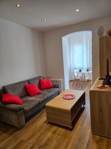ein Wohnzimmer mit Sofa und Tisch in der Unterkunft Apartamenty EverySky Karkonoska 54/7 in Bierutowice