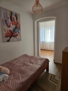 ein Schlafzimmer mit einem Bett und einem Gemälde an der Wand in der Unterkunft Apartamenty EverySky Karkonoska 54/7 in Bierutowice
