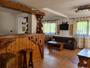 a living room with a couch and a table at Zori de Zi & Apus de Soare in Bălceşti