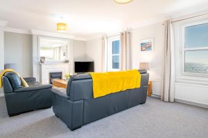 a living room with a couch and a yellow blanket at Pebble Reach in Amroth