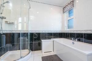 a white bathroom with a tub and a sink at Pebble Reach in Amroth +32 photos
