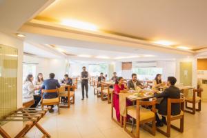 a group of people sitting at tables in a restaurant at FabHotel Kalyan in Vadodara