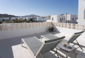 a patio with two chairs and a table on a balcony at WHITE W4 new studio in Naousa in Naousa