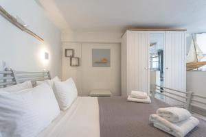 a bedroom with a white bed with towels on it at WHITE W4 new studio in Naousa in Naousa