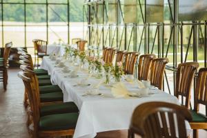 a long table with white table cloth and flowers on it at Gut Sarnow - Hotel und Restaurant in Schorfheide