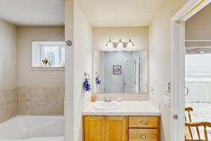 a bathroom with a sink and a tub and a mirror at Ocean Lover's Landing in Gold Beach +15 photos