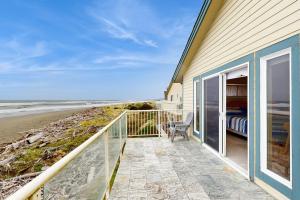 a balcony with a view of the beach at Ocean Lover's Landing in Gold Beach