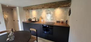een keuken met een zwart aanrecht en een tafel bij La Chambre de la Gotale in Manhay