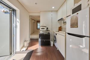 a small kitchen with a refrigerator and a microwave at Seoul Station ㅣThe interior of a hanok with a terrace in Seoul