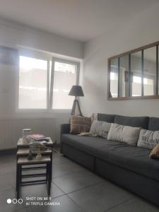 a living room with a couch and a table at La Suite by Nath in Calais