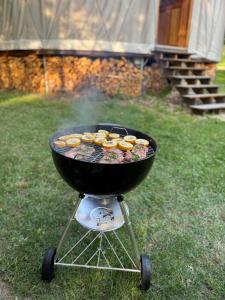 a grill with cupcakes cooking on it in the grass at Malá jurta na Souvrati in Mostek