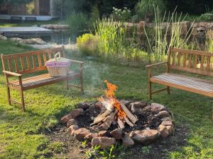 two benches sitting next to a fire in a yard at Malá jurta na Souvrati in Mostek