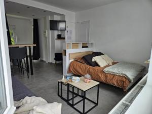a bedroom with a bed and a table in it at La Suite by Nath in Calais
