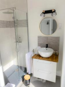a bathroom with a sink and a glass shower at La Suite by Nath in Calais
