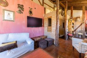 a living room with a couch and a flat screen tv at La Chatarrería De Ferreros-Otero in Otero de Herreros