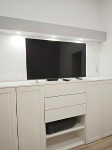 ein weißer Schrank mit einem Fernseher darüber in der Unterkunft Vibe City Apartment in Kecskemét