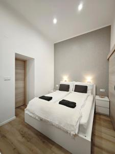 ein großes weißes Schlafzimmer mit einem großen weißen Bett in der Unterkunft Vibe City Apartment in Kecskemét