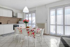 a kitchen with a table and chairs with flowers on it at Casa Martina in San Fermo della Battaglia