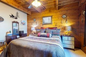 ein Schlafzimmer mit einem Bett in einer Holzwand in der Unterkunft 1 Little Rabbit in Pagosa Springs