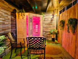 een veranda met twee stoelen en een roze deur bij bnbheerhugowaard in Heerhugowaard +5 foto's