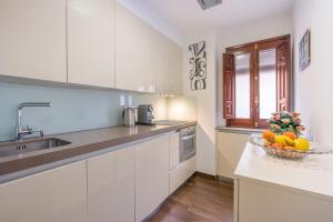 a kitchen with white cabinets and a bowl of fruit on a counter at City Center Lorca Suit Parking Free in Granada