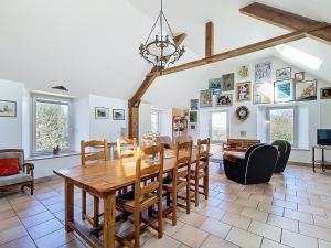 a dining room with a wooden table and chairs at La Mainerie in Jobourg