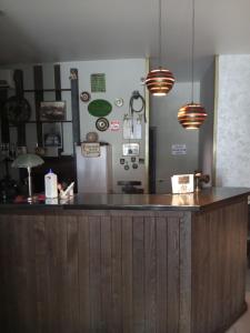 a kitchen with a bar with a refrigerator and pendant lights at Хостел Піонер 1 in Sumy