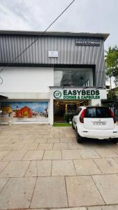 um carro branco estacionado em frente a um prédio em LF Easybeds em Calecute mais 15 fotografias