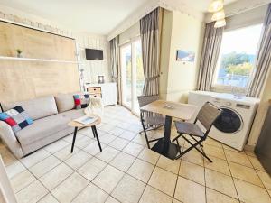 a living room with a couch and a table at Studio Vue sur le Lac d'Annecy Plage et Parking Privés in Duingt