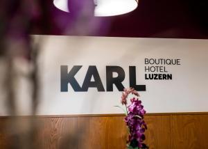 a sign for a hotel with a vase of flowers at Boutique Hotel KARL in Lucerne