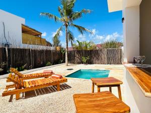 a backyard with benches and a swimming pool at U Paradisu Villas- 2 private pool villas in Kibigija