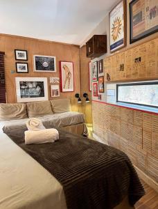 a bedroom with two beds and pictures on the wall at La Nueva Posadita in Colonia del Sacramento