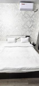 een bed met witte lakens en kussens in een slaapkamer bij New Cheap Apartments in Tashkent in Tasjkent
