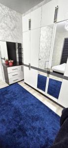 een kamer met een blauw tapijt en witte kasten bij New Cheap Apartments in Tashkent in Tasjkent