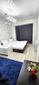een slaapkamer met een groot bed en een blauw kleed bij New Cheap Apartments in Tashkent in Tasjkent