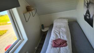 a bed in a small room with a window at Feriehuset Holmen in Straumen