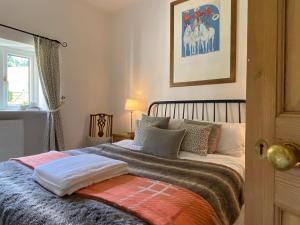 ein Schlafzimmer mit einem großen Bett mit Kissen darauf in der Unterkunft Pardlestone Farm Cottages in Kilve