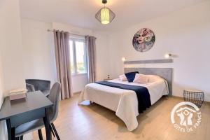 ein Schlafzimmer mit einem Bett, einem Tisch und einem Schreibtisch in der Unterkunft La rosalie in Visseiche