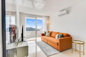 - un canapé orange dans le salon avec une fenêtre dans l'établissement Sea View Monteparaiso, à Puerto Rico