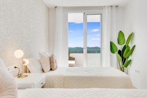 une chambre blanche avec deux lits et une fenêtre dans l'établissement Sea View Monteparaiso, à Puerto Rico 15 autres photos