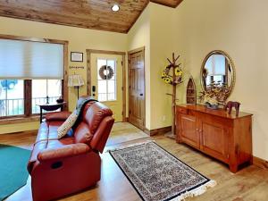 a living room with a leather couch and a mirror at Buzzy Bee Lodge in McHenry