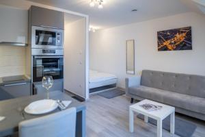 een woonkamer met een bank en een tafel bij Antracit Apartman - free parking in Pécs +8 foto's