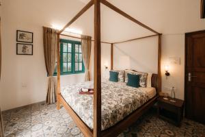 Schlafzimmer mit Himmelbett und blauen Kissen in der Unterkunft amã Stays & Trails - Assa 360 , Goa in Assagao