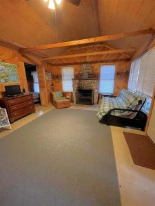 a living room with a fireplace in a log cabin at SWALLOW - LIMIT 4 cottage in North Sebago
