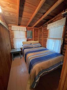 a bedroom with two beds in a log cabin at SWALLOW - LIMIT 4 cottage in North Sebago +3 photos