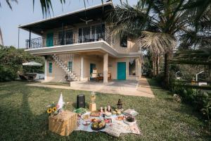 ein Picknick im Gras vor einem Haus in der Unterkunft amã Stays & Trails - Assa 360 , Goa in Assagao