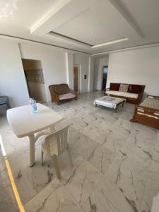 a large living room with a table and chairs at résidence Ferjani hechmi in Rafrāf +1 photo